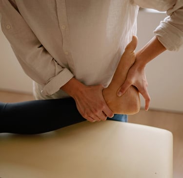 Une femme est allongée sur une table de massage, tandis qu'un thérapeute lui prodigue des soins.
