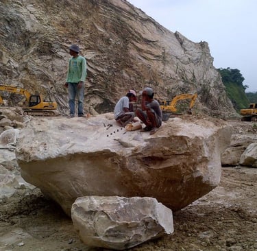 Proses awal penghancuran batu alam andesit primer di area tambang untuk persiapan pengiriman massal