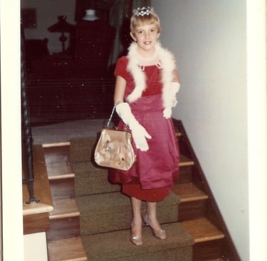 Vintage polaroid of a young girl in a red dress, tiara, and white boa for dress up.