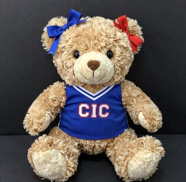 A variety of personalized water bottles and gear laid out on a sports field.