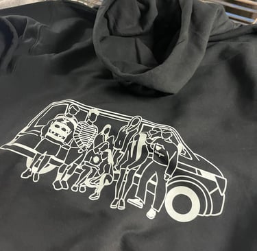 Black oversized hoodie with a white screen-printed graphic of a group of friends sitting on a van.