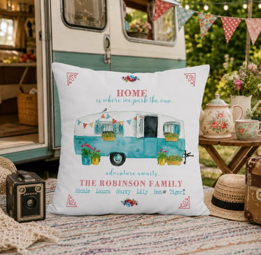 Personalised caravan family cushion displayed beside a vintage caravan with outdoor picnic setting. 