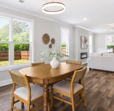 Dining room staged with a light wood table and neutral chairs in Anderson SC, by Staging House
