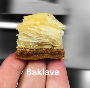 A piece of flaky Egyptian baklava with a secret sauce drizzled on crushed pistachios.