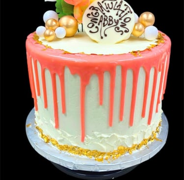 Custom graduation cake with pink drip frosting, gold leaf accents, and floral topper for Abby.
