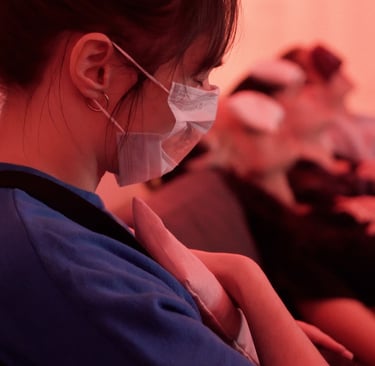 A masked person holds a lavender pillow while feeling their heartbeat with their hand.