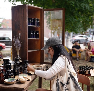 Une femme à une table dans un parc, prenant part à une installation d’art.