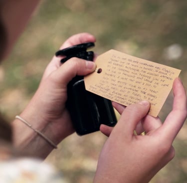 A woman holds an apothecary bottle with a handwritten note on the lid