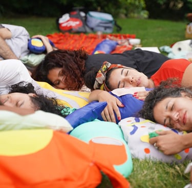 People rest on soft sculptures of body parts.