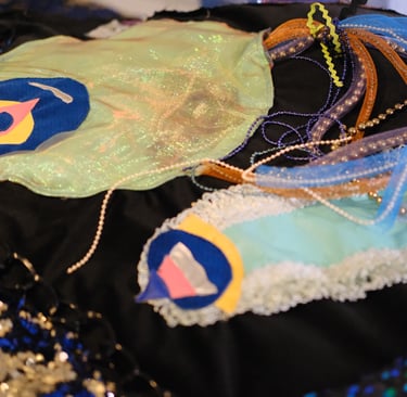 Two imagined underwater creatures that resemble jellyfish and a slug made out of textiles