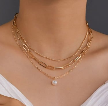 a woman wearing a white dress and a pearl necklace