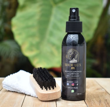 Shoe Lux sneaker cleaning kit with spray bottle, horsehair brush, and microfibre towel on wood.