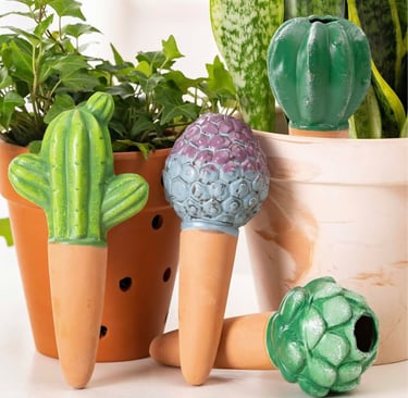 Decorative terracotta self-watering spikes shaped like cactus used as an automatic waterer