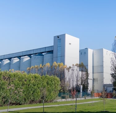 Stabilimento Agugiaro & Figna a Curtarolo con silos e struttura industriale immersa nel verde.