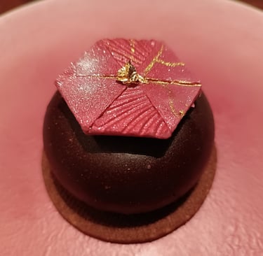 Dessert al cioccolato con decorazione geometrica rosa e foglia d'oro servito al ristorante Nobuya Milano