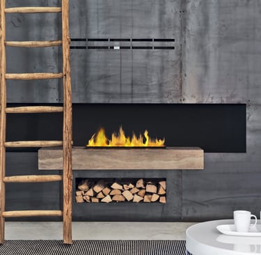 Camino moderno a parete su muro in cemento con legna a vista e scala in legno