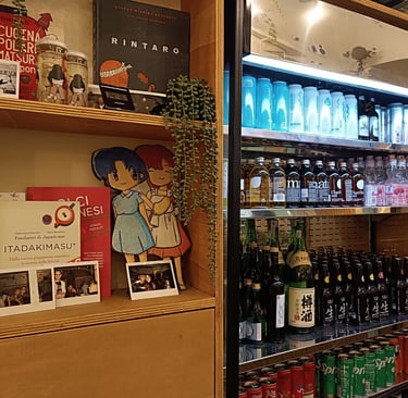 Scaffale con libri manga e frigorifero con bibite giapponesi da Maido