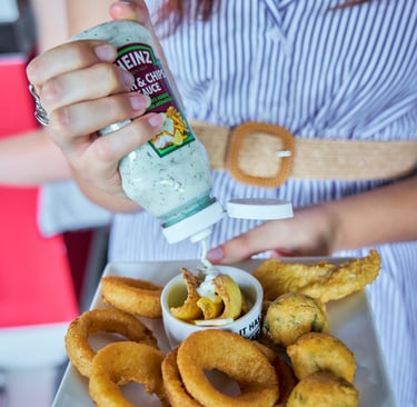 Heinz Fish & Chips Sauce servita con anelli di cipolla, calamari e fritti misti.