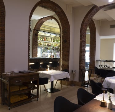 Sala principale del Quadri Bistrot a Milano con archi in mattoni e cocktail bar sullo sfondo