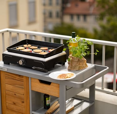 Plancha elettrica Campingaz utilizzata su un balcone cittadino.