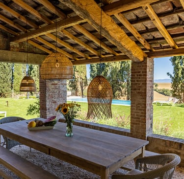 Grande tablée sous la pergola de Villa Violetta avec vue sur le parc et la piscine