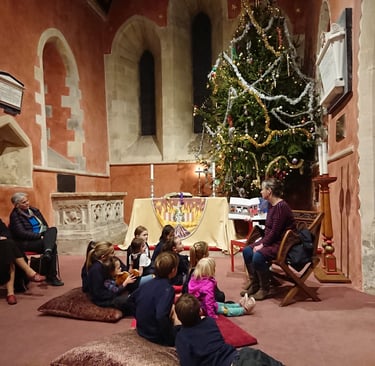 Children sit around the biggest Christmas Tree to hear stories