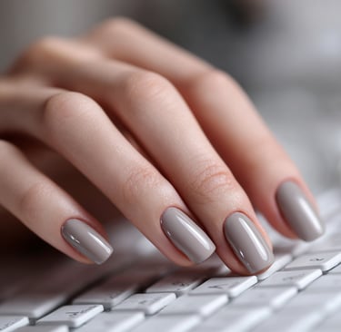 Minimal grey nude nails with thin French tips typing on a keyboard