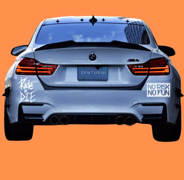 Rear view of a white BMW M4 sports car with custom stickers and quad exhaust on an orange background.