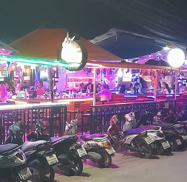 Outside view of bars at Wonderland bar complex in Hua Hin under neon lights
