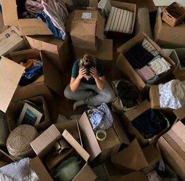 Person buried in collapsed cardboard moving boxes why reusable totes are better