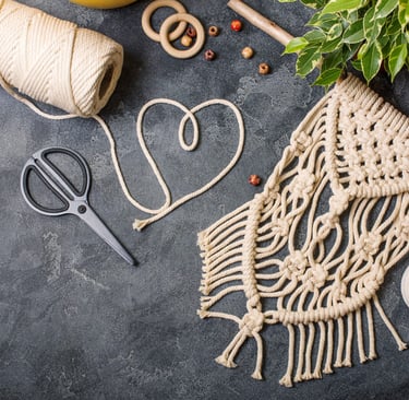 tejido de macramé con un corazón y tijeras en una mesa
