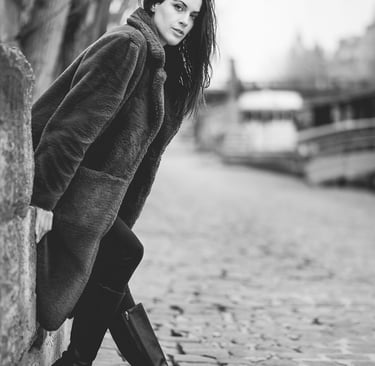 Portrait en noir et blanc d’une femme en manteau sur les quais de Seine à Paris, ambiance hivernale et lifestyle.