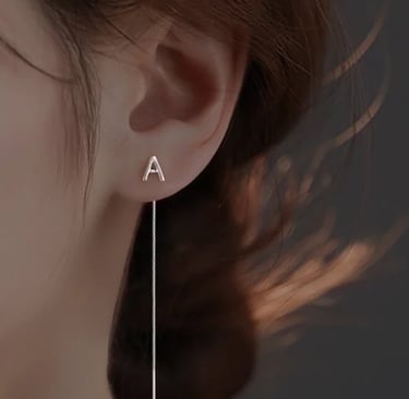 a woman wearing a pair of earrings with a long line of earrings