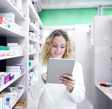 a woman in a pharmacy office setting holding a tablet computer