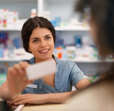 a woman in a pharmacy office setting with a business card