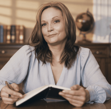 a woman sitting at a table with a book and a book