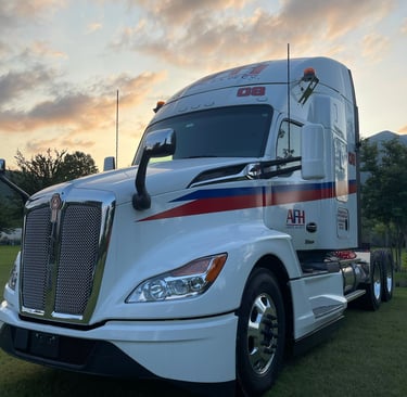 Tractocamión AFH Logistics bajo un cielo al atardecer, listo para carga