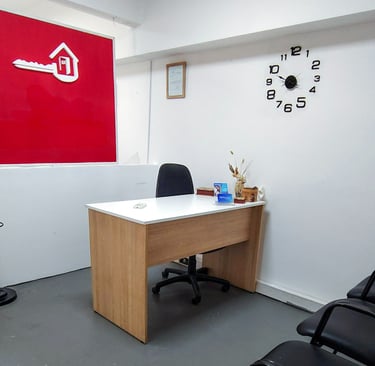 Recepción de Red de Llaves con mostrador blanco, pared roja institucional y luz natural desde el frente.