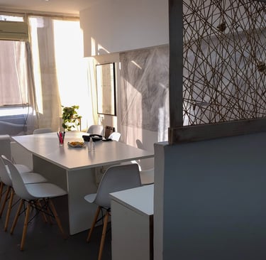 Sala de firmas en Red de Llaves con mesa blanca, luz natural y detalles decorativos sobre la cómoda.