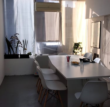 Sala de firmas en Red de Llaves con mesa blanca, sillas modernas y luz natural entrando por el ventanal.