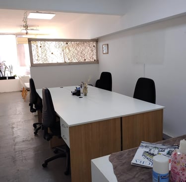 Espacio de trabajo en Red de Llaves con escritorios individuales, silla blanca y luz natural tenue.