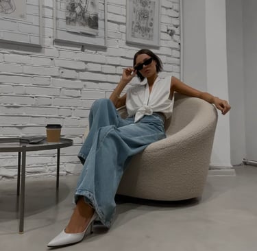 Chica juvenil con outfit moderno sentada en sillón minimalista