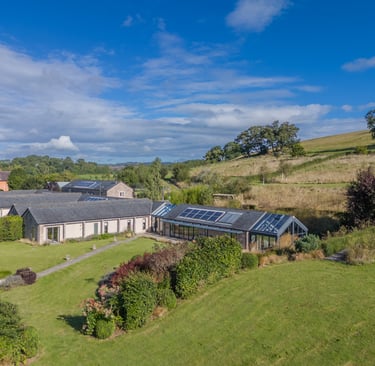 a stunning barn conversion with a large lawn and solar panels
