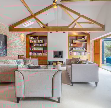 a living room with a couch and a fireplace and wooden beams