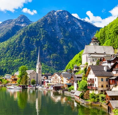 Panoramic view of Hallstatt, a charming lakeside village with historic buildings, lush mountains, and serene water in