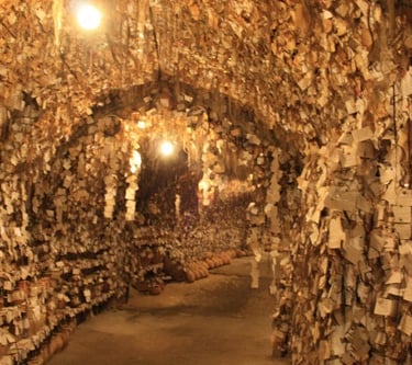 The interior of the Avanos Hair Museum in Turkey, featuring thousands of hair samples and notes on cave walls.