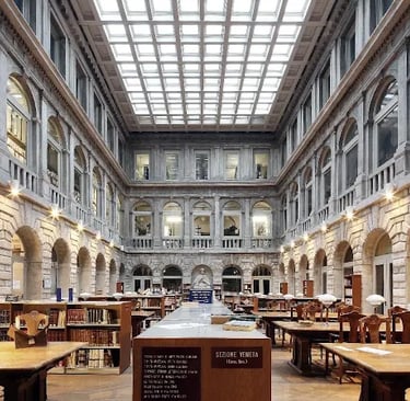Historic Italian library interior with classic wooden study desks and a large glass atrium ceiling.