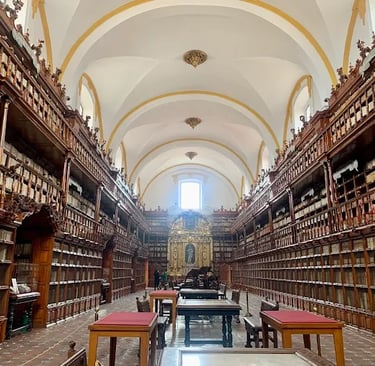 Historic university library with ornate wooden bookshelves and vaulted ceilings.