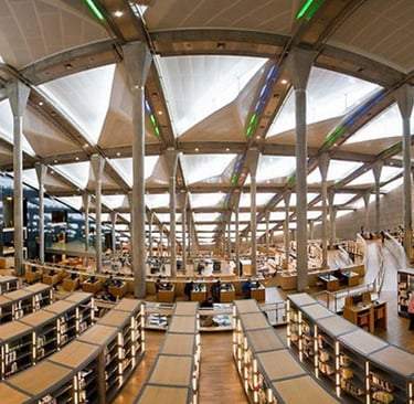 Modern interior of the Bibliotheca Alexandrina library in Egypt featuring tiered reading areas and skylights.