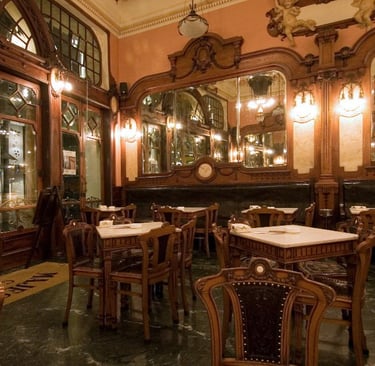 Elegant Art Nouveau interior of Majestic Cafe in Porto featuring ornate wood carvings and mirrors.